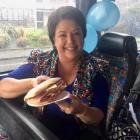 Paula shows off her panini, wearing a jacket that blends very well with the bus seats. Photo /...