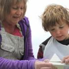 Linda Wilson, of Weston, shows Arthur Gillespie (9), of Nelson, how to carve his pyramid. Arthur...