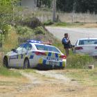 Police gather beside Lowburn Valley Rd, near Cromwell, as the search for an armed teenager...