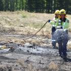 Firefighters douse a small scrub fire near Alexandra this afternoon. Photo: Tom Kitchin