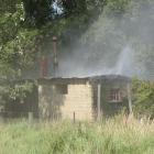 Smoke spews from a holiday house in Ophir. Photo: Pam Jones