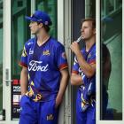 Otago players Warren Barnes (left) and Neil Wagner shelter from the rain as they wait in vain for...