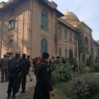 Police and rescue workers stand outside the Directorate of Agriculture Institute in Peshawar....