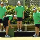 Caleb Hope (front left with mat) checks a measure from a bowl on the edge of the green to the...