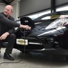 Auto Court manager Nelson Cottle demonstrates how to charge one of the two Nissan Leaf electric...