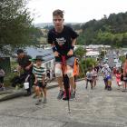 Harry Willis (11) bounces his way up the world’s steepest street on a pogo stick this morning....