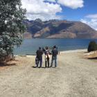 The parents and brother of missing American man Tyler Nii look across Lake Wakatipu from the...