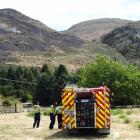 A Wanaka volunteer fire crew monitors a spot fire 300m up the eastern flank of Mt Alpha. PHOTO:...