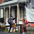 An investigator enters the South Dunedin property where two people died in a fire on Monday....