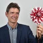 Diabetes researcher Dr Alex Tups holds a dahlia which could hold the key to diabetes prevention....