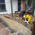Students save a flat from being inundated. Photo: Jack Cranston