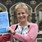 Prof Helen Nicholson holds a copy of the celebration schedule for the University of Otago's 150th...