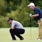 Leader  Terry  Pilkadaris, of Australia, is watched by  Greg Smale as he  examines a green before...