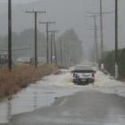 Farm traffic continues to use a flooded Papakaio Rd, north of Oamaru, on Wednesday. Photo: Hamish...