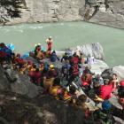 Friends, family and colleagues gather on the bank of the Shotover River on Sunday. PICTURES:...