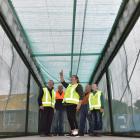 Project Kereru director Nic Hurring (centre) inspects the shipping container-aviary which is...