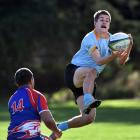 University winger Cam Gerlach catches the ball while Harbour winger Ngana Nicholas looks to...