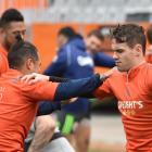 Highlanders first five-eighth Fletcher Smith (R) warms up for training with halfback Aaron Smith...