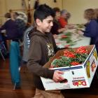 Cobie Smith (9) gathers the posies created in the HMNZS Toroa Dunedin naval reserve headquarters...