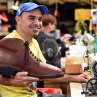 Former refugee Mohamad Ghanam holds a giant shoe at his workplace, McKinlay’s Footwear. Photo:...