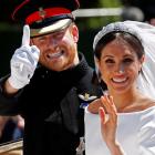 The Duke and Duchess of Sussex wave as they ride in a horse-drawn carriage after their wedding...