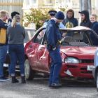 A group stands round a damaged car in Hyde St, Dunedin. Photo: Peter McIntosh