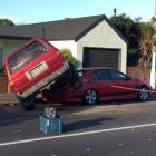 The 4WD ended up on the back of a Ford Falcon parked on the street after the crash. Photo: Gregor...