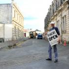 Harbour Street Bakery owner Ed Balsink carries a sign for the Tyne St entrance of Harbour St to...
