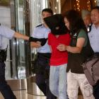 A female suspect is arrested by police officers after a woman opened fire and wounded four people...