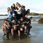 As many East Otago High School pupils as possible squeeze on to one of the Moeraki Boulders...