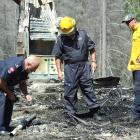 Police and firefighters inspect the scene of the Mt Aurum homestead fire at Skippers, near...