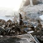 Guards walk on the wreckage of a building destroyed by air strikes in Sanaa. Photo: Reuters