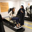 A driving instructor (R) explains seat bells to trainees Amira Abdulgader and Maria Al-Faraj (C)...