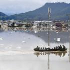 Residents are rescued from a flooded area by Japan Self-Defence Force soldiers in Kurashiki....