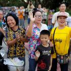 Onlookers wave as an ambulance carrying rescued schoolboys leaves a military airport in Chiang...