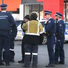 Stabbing victim Todd Casey talks to police officers at the Andersons Bay Rd branch of Burger King...