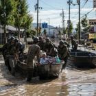 Soldiers ferry elderly people to safety following heavy flooding in Kurashiki near Okayama, Japan...