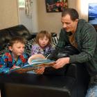 Parent Brendan Selwood reads to his children Alex (6) and Emily (8) at their Brighton home, in...