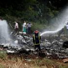 A firefighter works in the wreckage of a Boeing 737 plane that crashed in the agricultural area...