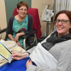 Dunedin Hospital patient Tracy de Woeps (right) reads a poem provided by Poems in the Waiting...