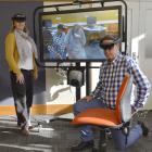 Nursing School head Ian Crabtree kneels beside a seated holographic patient, who is invisible to...