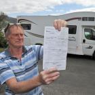 Macandrew Bay retiree Neil Morris holds a freedom camping ticket he received recently while...