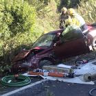 Firefighters work to extract the driver of a car following a crash at Kuri Bush, south of...