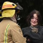 A woman clutches her rabbit after narrowly escaping a house fire in Dunedin yesterday morning....