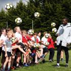Tottenham Hotspur international development coach Anton Blackwood shows the pupils of Fairfield...