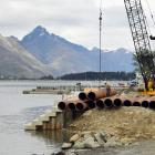 A crane moves pipes at the Frankton marina site. Photo: Stephen Jaquiery