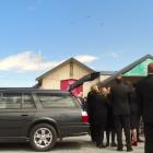 Mourners watch a fly-past of Glenorchy Air planes after the funeral of the company's co-founder,...