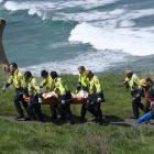 Firefighters carry German tourist Johanna Langner (25) up the steep access track at Tunnel Beach...