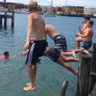Children jump off the wharf at a boat ramp in Bluff in January. Photo: Sharon Reece