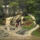 Water gushes down the hill in front of a Ravensbourne house yesterday. Photo: Gregor Richardson